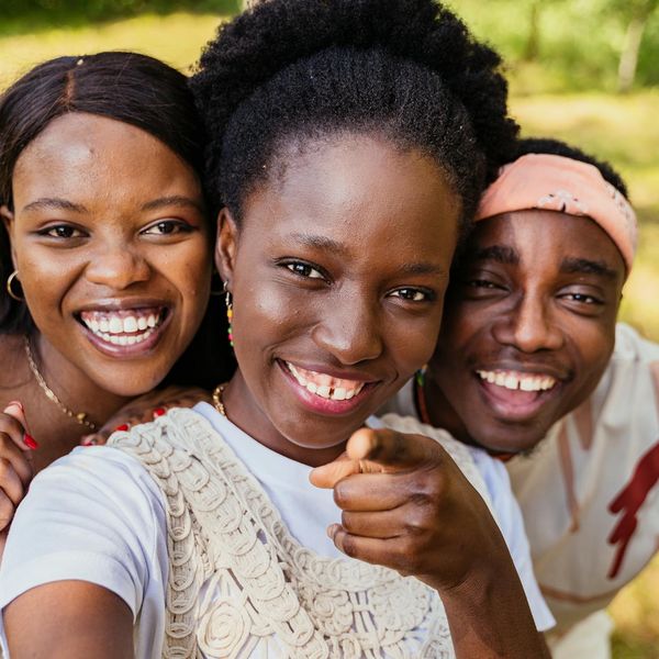 A diverse group of people smiling during a light yoga session.